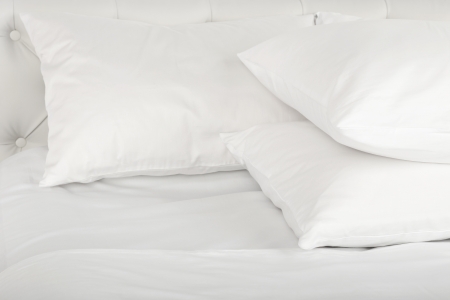 Federkissen Drei weiße Federkissen im Bett
