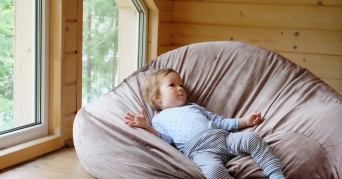 Sitzkissen Kinder Kind liegt auf einem Kinder Sitzkissen