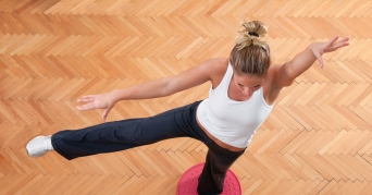 Balance Kissen Frau balanciert auf einem Balance Kissen