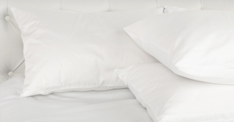 Federkissen Drei weiße Federkissen im Bett