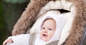 Kinderwagen Kissen Kind sitzt glücklich auf einem Kinderwagen Kissen