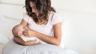 Frau benutzt Stillkissen zum Stillen ihres Babys